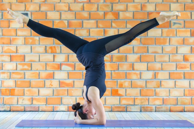Estagiário asiático forte mulher praticando difícil yoga pose