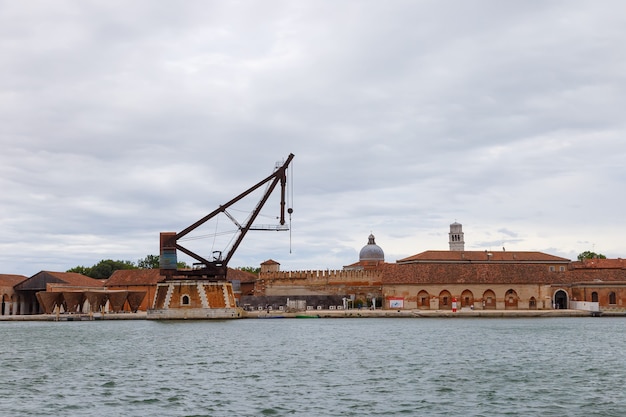 Estaleiros industriais (Arsenale di Venezia) na Itália, Veneza. Carregando guindastes e docas.