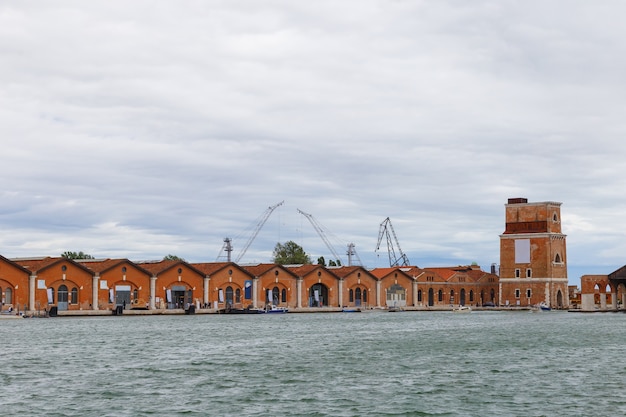 Estaleiros industriais (Arsenale di Venezia) na Itália, Veneza. Carregando guindastes e docas.