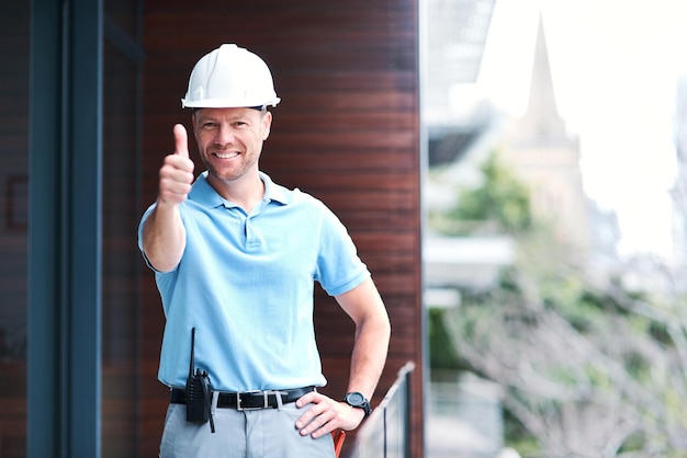 Estamos listos para ponernos en marcha Retrato de un ingeniero alegre posando con los pulgares hacia arriba fuera de un edificio