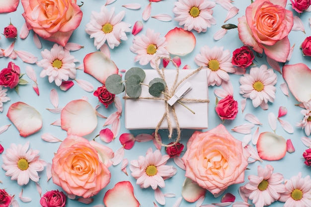 Foto estampado de flores de capullos de rosas, camomiles y pétalos sobre fondo azul.