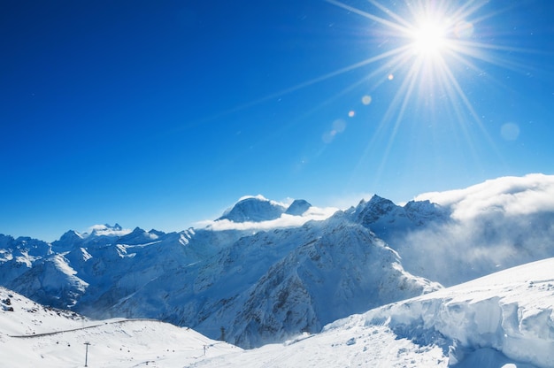 Estância de esqui Elbrus. Cáucaso, Federação Russa. Bela paisagem de inverno com montanhas cobertas de neve e céu azul