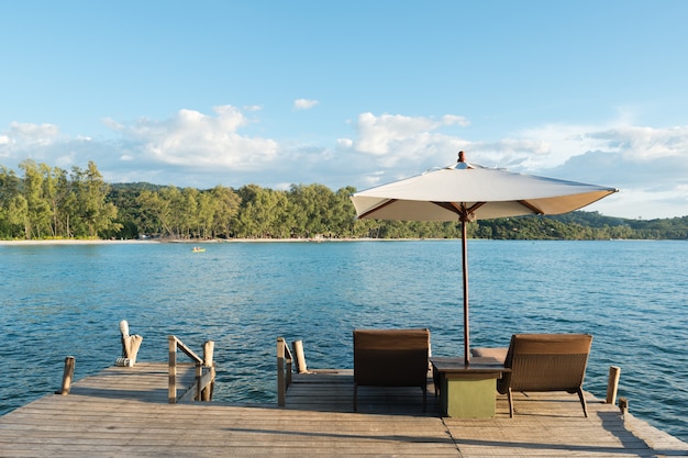 Estância de verão tropical com cadeiras e guarda-chuvas de sala de estar em Phuket, Tailândia.