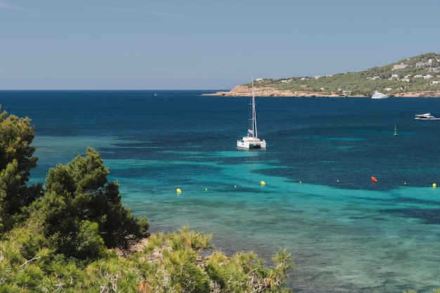 Foto estancia en yate de vela en la bahía de ensueño con agua turquesa transparente isla de ibiza españa