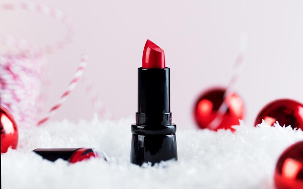 Estandarte de Navidad con lápiz labial rojo en la nieve y bolas de Navidad copia espacio