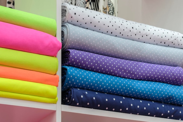 Estante con una amplia selección de telas coloridas Cintas coloridas en el estante de la tienda Industria textil