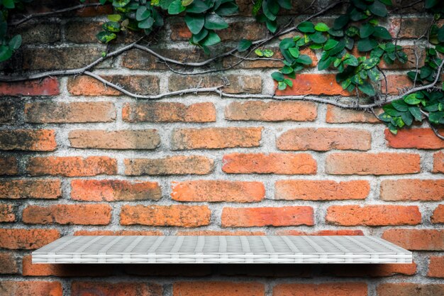 Estante blanco vacío en el fondo de la pared del jardín de ladrillo para la exhibición del producto