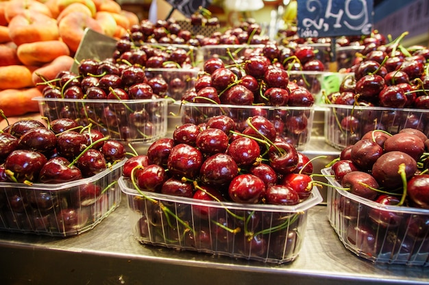 Estante con cajas de cerezas, delicioso postre en supermercado