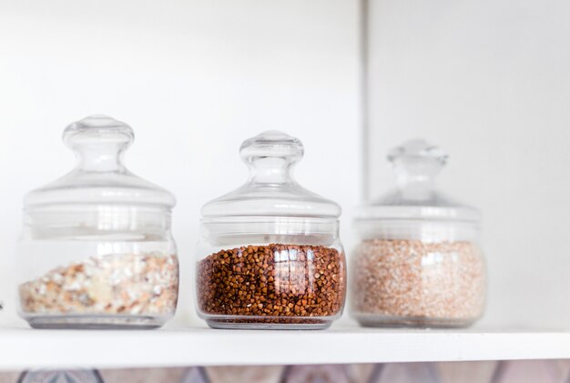 En el estante de la cocina hay frascos de vidrio con cereales. Foto