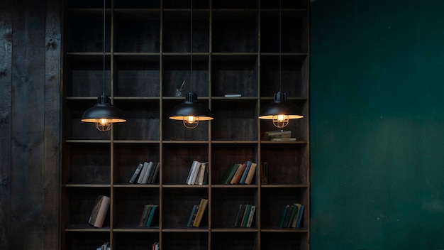 Estante com livros na biblioteca iluminada por lâmpadas