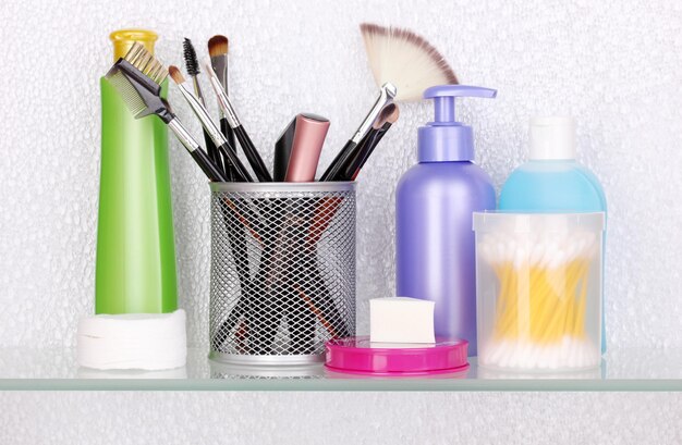 Estante con cosméticos y artículos de tocador en el baño.