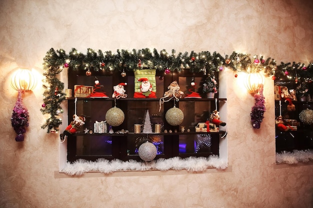Estante decorativo con adornos navideños en la pared del salón. concepto de vacaciones