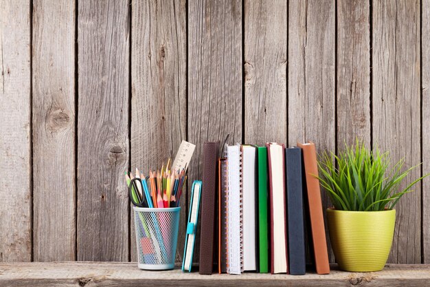 Estante de madera con libros y suministros.