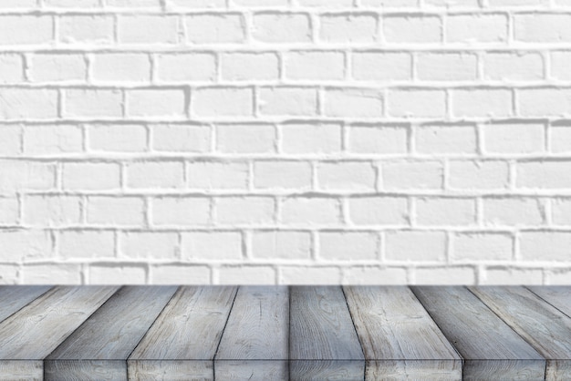 Estante de madera o mesa delante de un fondo de pared de ladrillo blanco limpio y vacío con espacio para texto o ideas