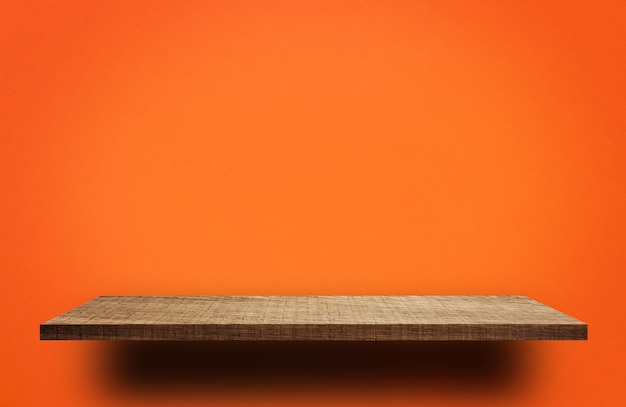 Foto estante de madera vacío sobre fondo naranja para exhibición de producto