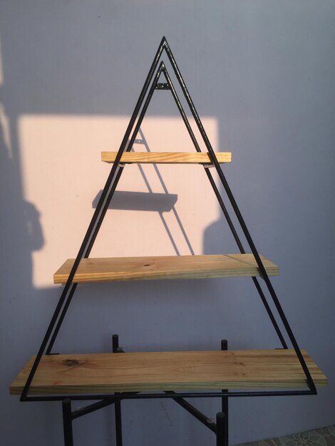 Estanterías de pared hechas de teca y modelo triangular de hierro