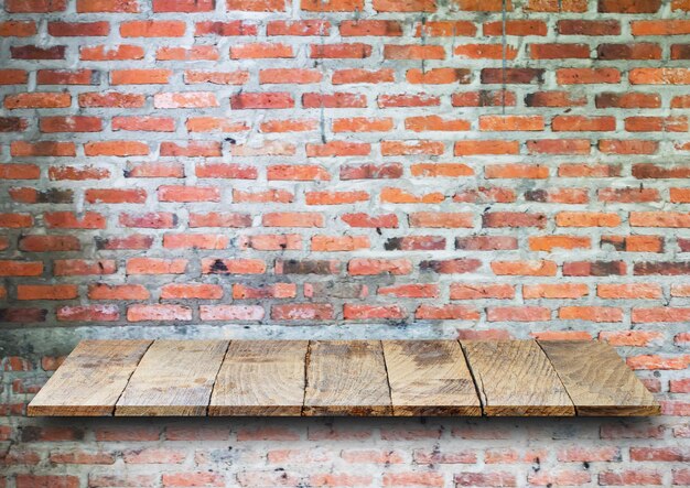 Estantes de madera superiores vacíos y fondo de pared de ladrillo de piedra