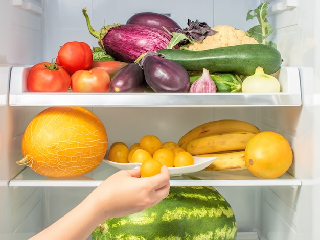 Estantes en el refrigerador con verduras y frutas.