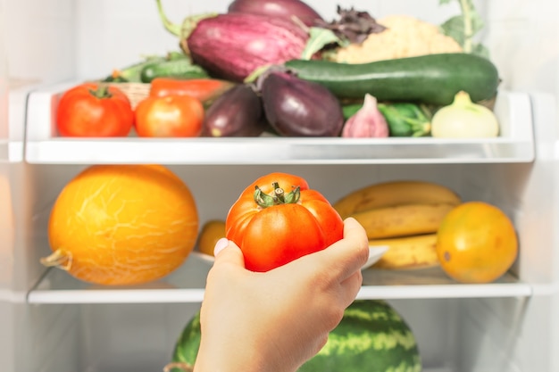 Estantes en el refrigerador con verduras y frutas.