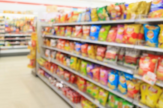 Foto los estantes de las tiendas de conveniencia de los supermercados con bocadillos de papas fritas borrosos fondo abstracto