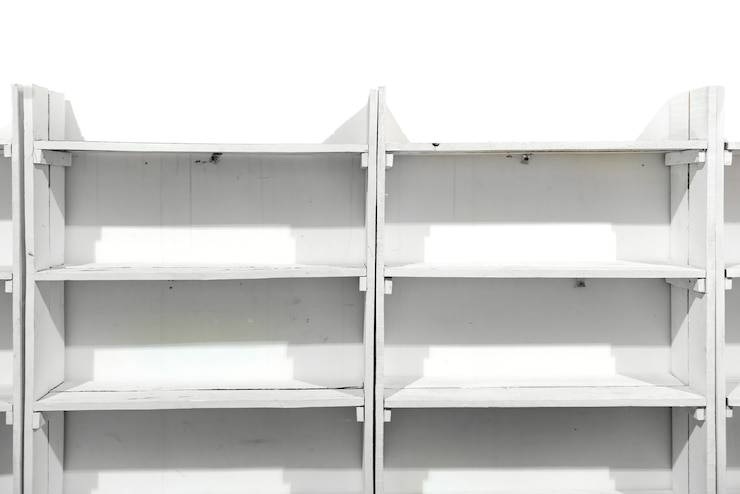 Foto estantes vacíos de madera blanca en la pared de la tienda