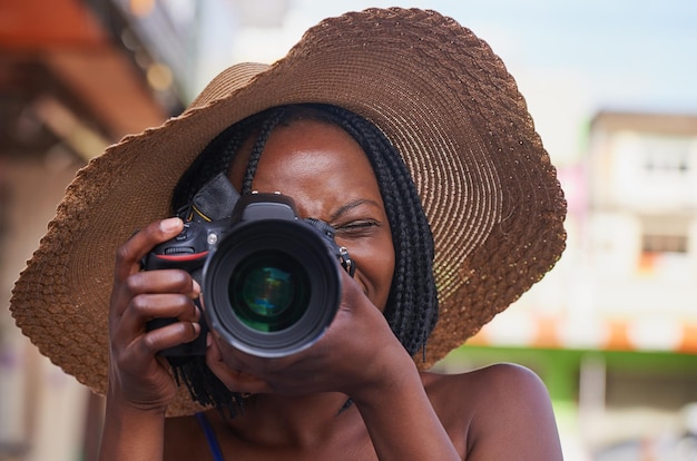 Estás buscando una imagen perfecta Retrato de un joven turista feliz tomando fotos con su cámara en una ciudad extranjera