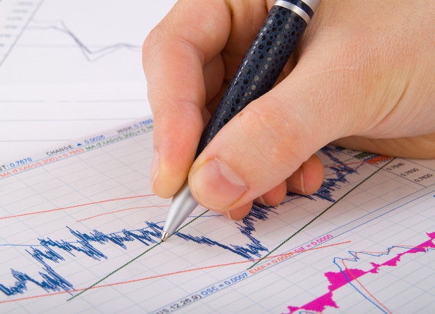 Estatísticas financeiras documentos infográficos de caneta esferográfica na mesa de escritório