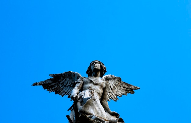 Una estatua de un ángel con alas y cola.