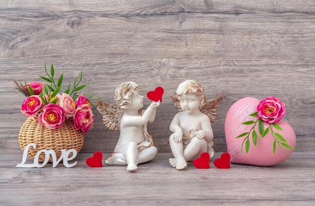 Foto la estatua de ángel de mármol está decorada con flores y un corazón decorativo