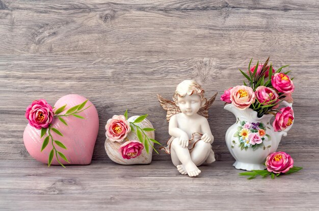 Foto la estatua de ángel de mármol está decorada con flores y un corazón decorativo