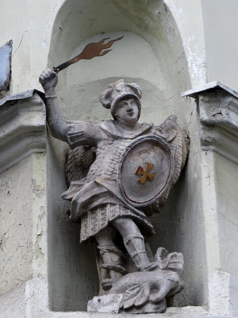 Estatua del ángel San Jorge con alas detrás de su espalda y la espada ardiente