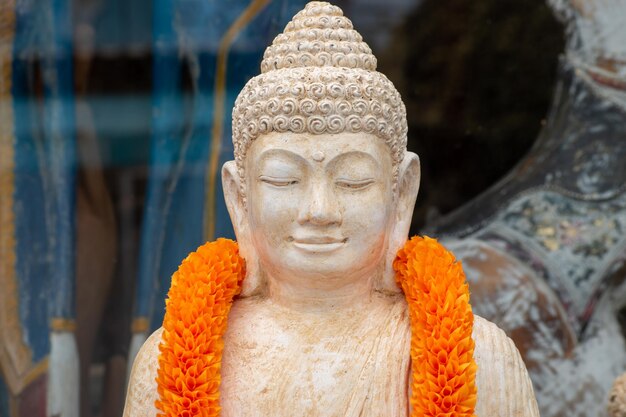 Foto una estatua del autor con una guirnalda naranja a su alrededor.