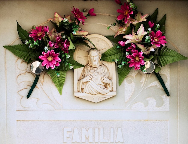 Una estatua blanca de un hombre con flores.