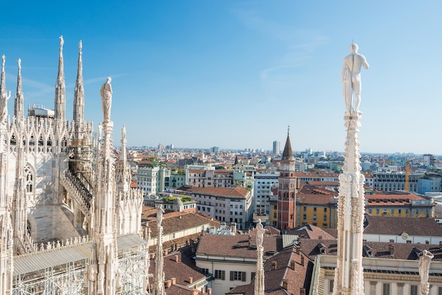 Estatua blanca en la parte superior de la catedral del Duomo y vista a la ciudad de Milán