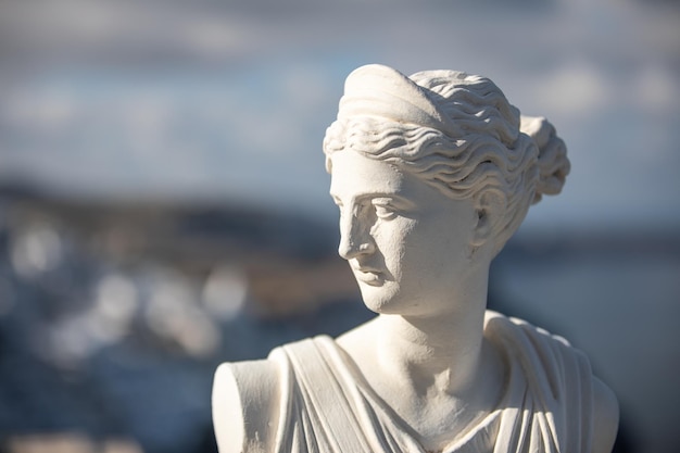 Estátua branca de Ártemis, deusa Diana com vista turva de Santorini Fira Grécia. retrato histórico