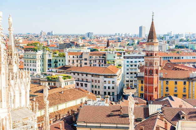 Estátua branca no topo da catedral duomo e vista da cidade de milão