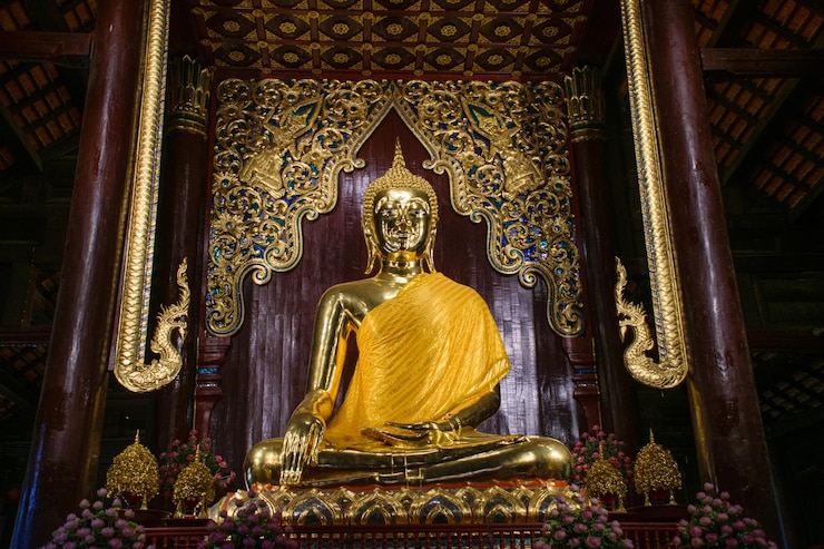 Una estatua de un buda dorado se sienta en un templo.