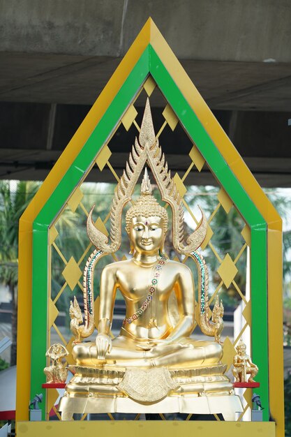 Estatua de Buda de oro con artefacto aura verde detrás.