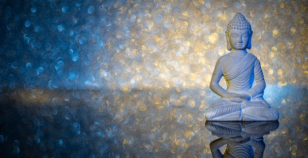 Estatua de Buda de piedra iluminada en acrílico subterráneo frente a un fondo iluminado
