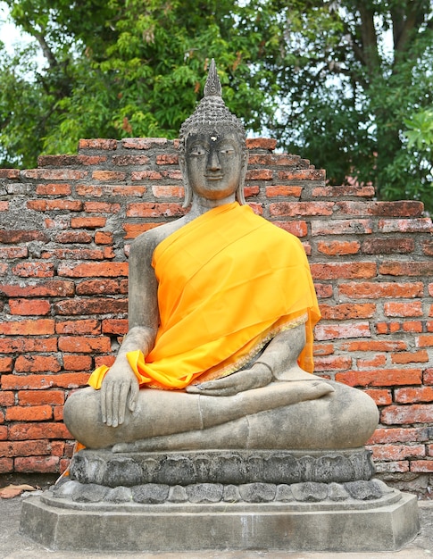 Estatua de Buda en ropa de tela sagrada amarilla