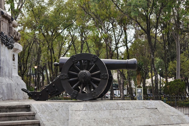 Una estatua de un cañón se sienta en un parque