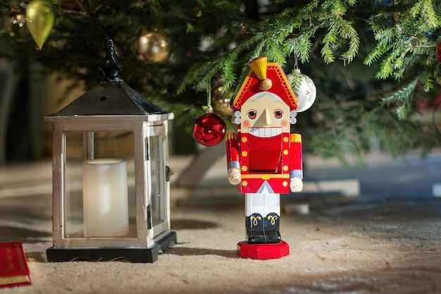 Estatua de cascanueces de pie frente al árbol de Navidad decorado