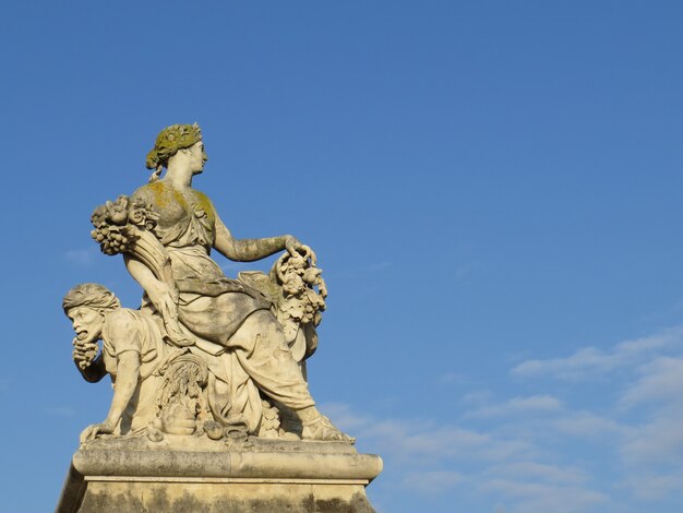 Estatua con cielo azul y nubes.