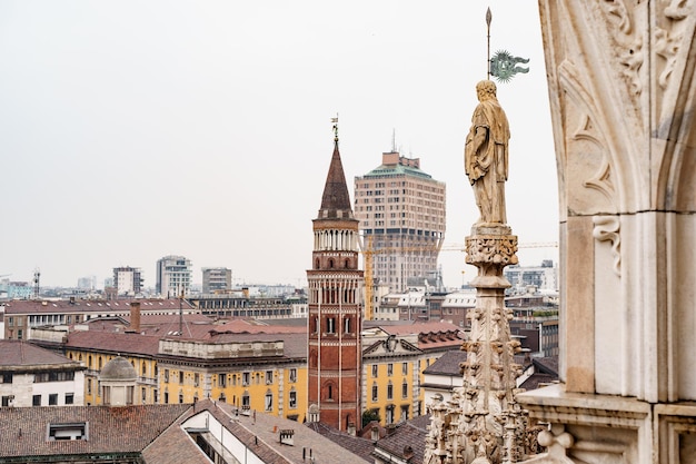 Estátua com uma bandeira na torre do duomo itália de milão