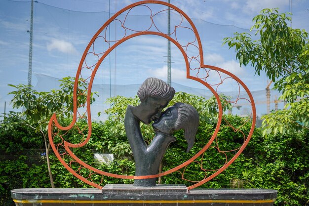 Estatua contra árboles y plantas contra el cielo