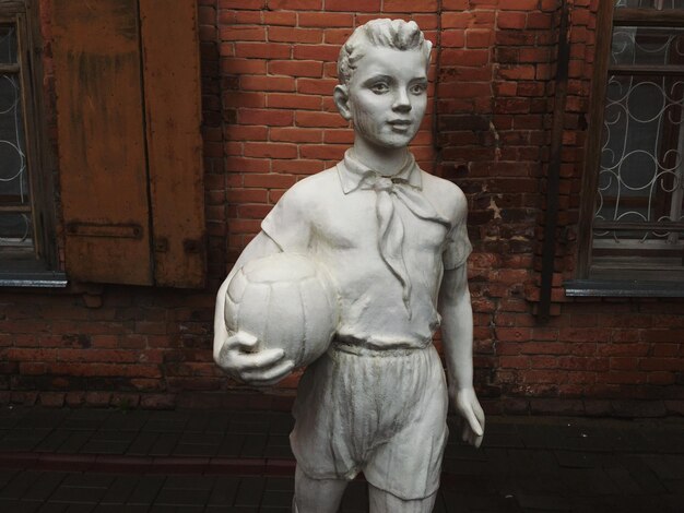 Foto estatua contra la pared de ladrillo