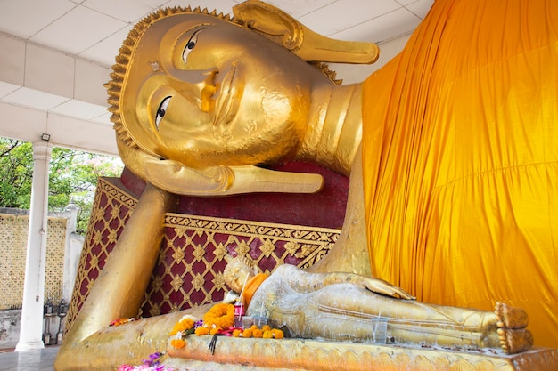 Estátua de atitude reclinada de Buda do templo de Wat Ku ou Phra Nang Rua Lom para os viajantes tailandeses, visitam e respeitam a bênção de oração, desejam adoração sagrada e misteriosa em Pak kret em Nonthaburi, Tailândia