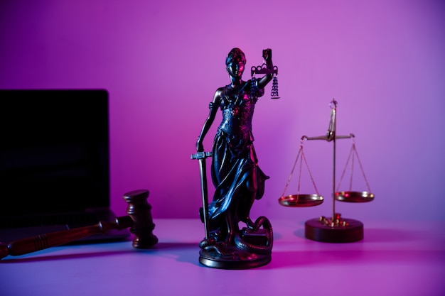 Estátua de bronze da senhora justiça com balança em cartório em fundo roxo