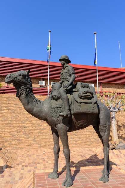 Estátua de bronze de um policial sul-africano em uniforme do deserto em um camelo