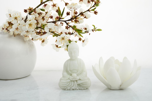 Estátua de buda de aniversário de buda vesak wesak com cereja florescendo em fundo branco ritual de spa